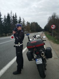 Policjant ruchu drogowego dokonujący pomiaru prędkości na jednej z dróg publicznych powiatu białostockiego