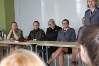 Fotografia kolorowa przedstawiająca kobiety w mundurach z różnych formacji. Po prawej stronie prowadząca dyskusję Naczelnik Wydziału Prewencji Komendy Miejskiej Policji w Białymstoku.