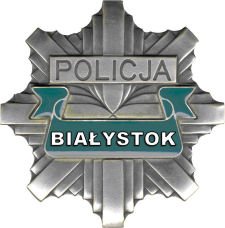 fotografia kolorowa przedstawiająca odznakę policyjną z napisem policja a pod spodem Białystok