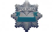 Fotografia kolorowa przedstawiająca odznakę policyjną z napisem policja