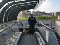 Policjant zjeżdżający z psem ruchomymi schodami