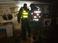 Fotografia kolorowa przedstawiająca  strażnika miejskiego i ratownika z Grupy ratowniczej Nadzieja stojących tyłem
