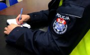Fotografia kolorowa przedstawiająca naszywkę z napisem Wydział Patrolowo-Interwencyjny Komendy Miejskiej Policji w Białymstoku umiejscowioną na ramieniu policjanta