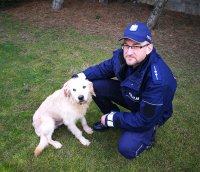 Fotografia kolorowa przedstawiająca policjanta z psem