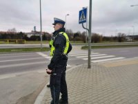 Fotografia kolorowa przedstawiająca stojącego policjanta z białostockiej drogówki.