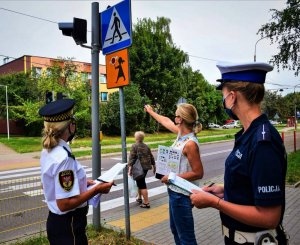 policjantka wraz z strażniczką miejską sprawdzają znaki przy szkołach i przejściach