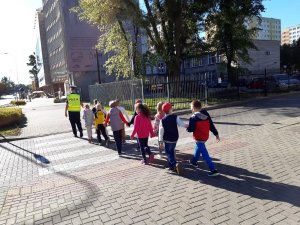 Dzieci przechodzące przez przejście wraz z policjantką