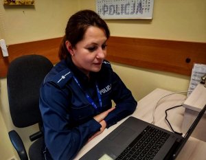 policjantka siedząca przed laptopem podczas lekcji online