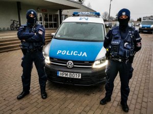umundurowani policjanci z białostockiej &quot;patrolówki&quot;, którzy stoją przed oznakowanym radiowozem