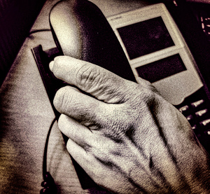 Dłoń trzymająca słuchawkę telefonu.