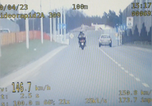 Zrzut ekranu z monitora wideorejestratora, na nim widoczny motocyklista.