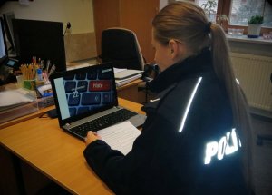 policjantka która siedzi przed laptopem