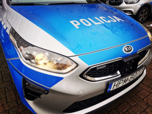 Maska samochodu a na niej napis Policja białymi literami