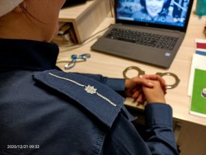 Pagon policyjny na ramieniu policjantki w tle Funkcjonariuszka z Nadleśnictwa na ekranie monitora