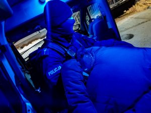 Policjant z Oddziału Prewencji Policji w Białymstoku, który trzyma zatrzymanego mężczyznę