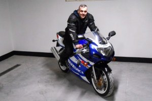 Tomasz Narel w kostiumie motocyklowym, siedzi na jednośladzie
