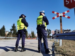 Policjant i Strażnik Ochrony Kolei stojący przed torami
