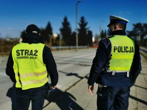 Policjant i Strażnik Ochrony Kolei obserwujący ruch