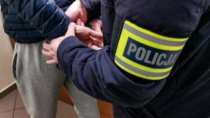 POLICJANT W UBRANIACH CYWILNYCH ZAKŁADA KAJDANKI MĘŻCZYŹNIE