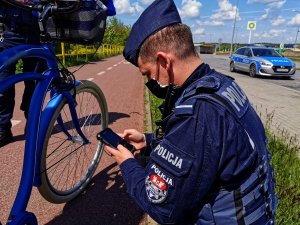 policjant, który sprawdza niebieski rower