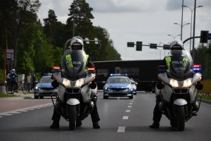 policyjne motocykle z mundurowymi. w Tle policyjny radiowóz
