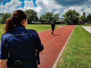 policjantka podczas prowadzenia biegu na bieżni, na terenie szkoły