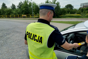 Policjant dokonujący pomiaru stanu trzeźwości kierowcy