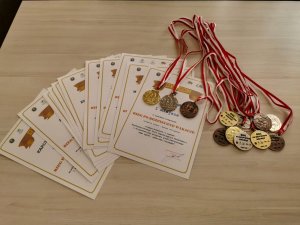ułożone na stole dyplomu oraz medale zwycięzcom biegu