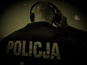 policjant stojący tyłem z założonymi słuchawkami