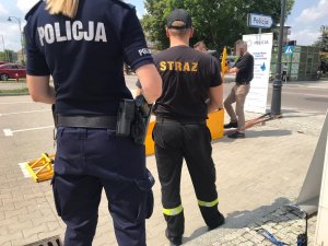 Policjant i strażak stojący tyłem w tle mężczyzna