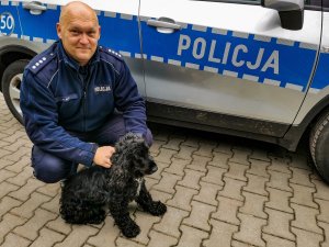 umundurowany policjant wraz z uratowanym czarnym psem
