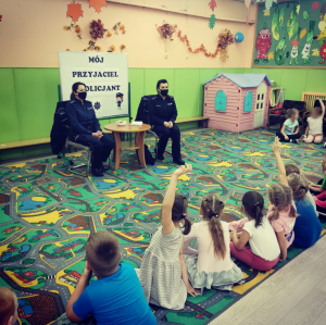 POLICJANTKI SIEDZĄCE PRZED DZIEĆMI