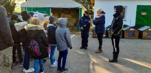 policjantka przy radiowozie, obok przekazana karma do schroniska