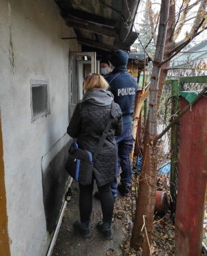 Dwóch policjantów i kobieta sprawdzający miejsca przebywania osób bezdomnych.