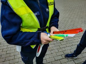 Policjantka trzymająca w rękach odblaski