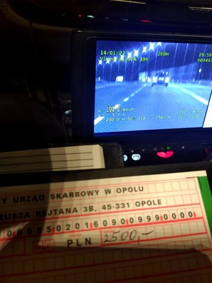 Ekran wideorejestratora, na którym widać pojazd, pod spodem mandat karny z wypisana kwotą 2500 złotych