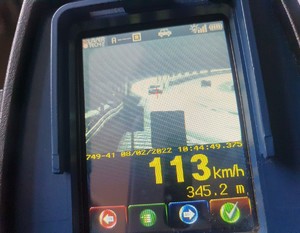 Ekran urządzenia do pomiaru prędkości z wynikiem 113 kilometrów na godzinę.