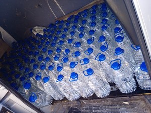 Wiele butelek z przezroczystą cieczą w samochodzie.