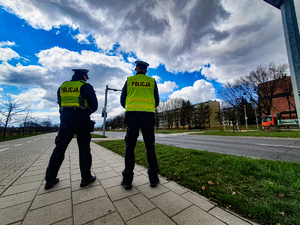Dwóch policjantów stojących przy przejściu dla pieszych.