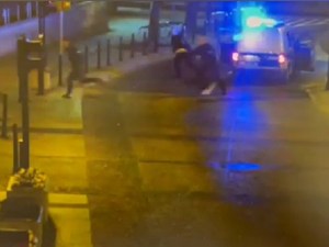 Zdjęcie z nagrania z monitoringu. Uciekający mężczyzna i biegnący za nim policjanci.
