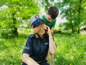 Dziecko zasłania policjantce oczy.