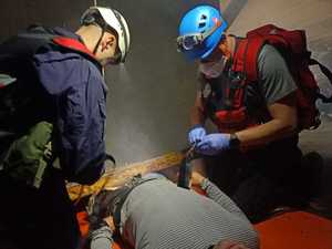 Dwóch ratowników - policjantów udziela poszkodowanej osobie pierwszej pomocy, symulantowi.