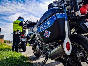 policjanci stojący przy policyjnym motocyklu