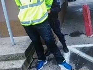 Policjantka trzyma zatrzymanego mężczyznę.