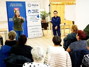 Policjantka i tłumaczka migowego na spotkaniu z osobami niesłyszącymi.