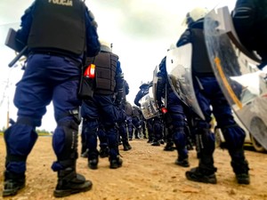 Policjanci z tarczami stojący tyłem