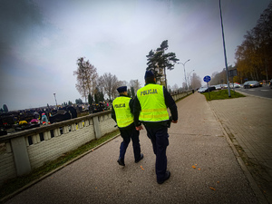 Policjanci idący chodnikiem.