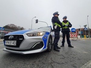 Policjanci przy radiowozie.