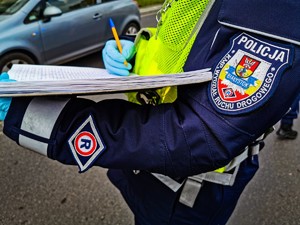 Policjant dokonujący zapisu w notatniku