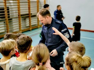 Policjant rozmawiający z dziećmi.
